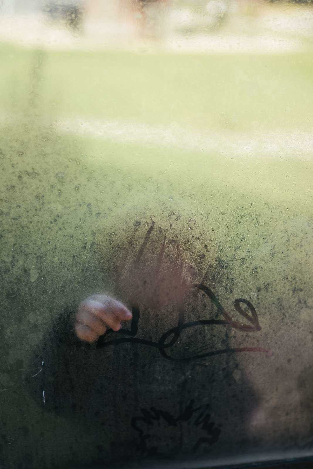 Billede af barn bag en dugget rude