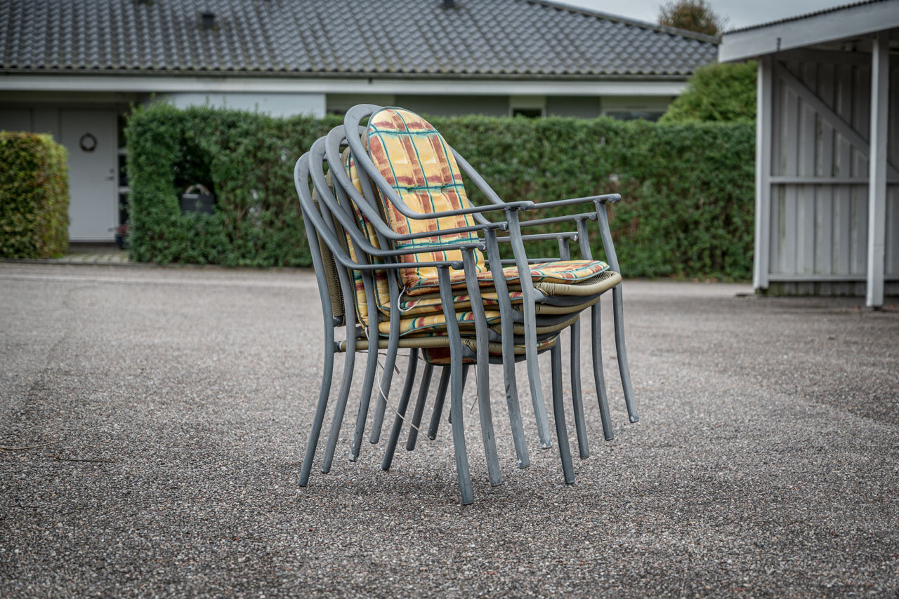 Foto af en stabel ekstra havestole som et eksempel på en genstand, man med fordel kan være fælles om i et delefællesskab.