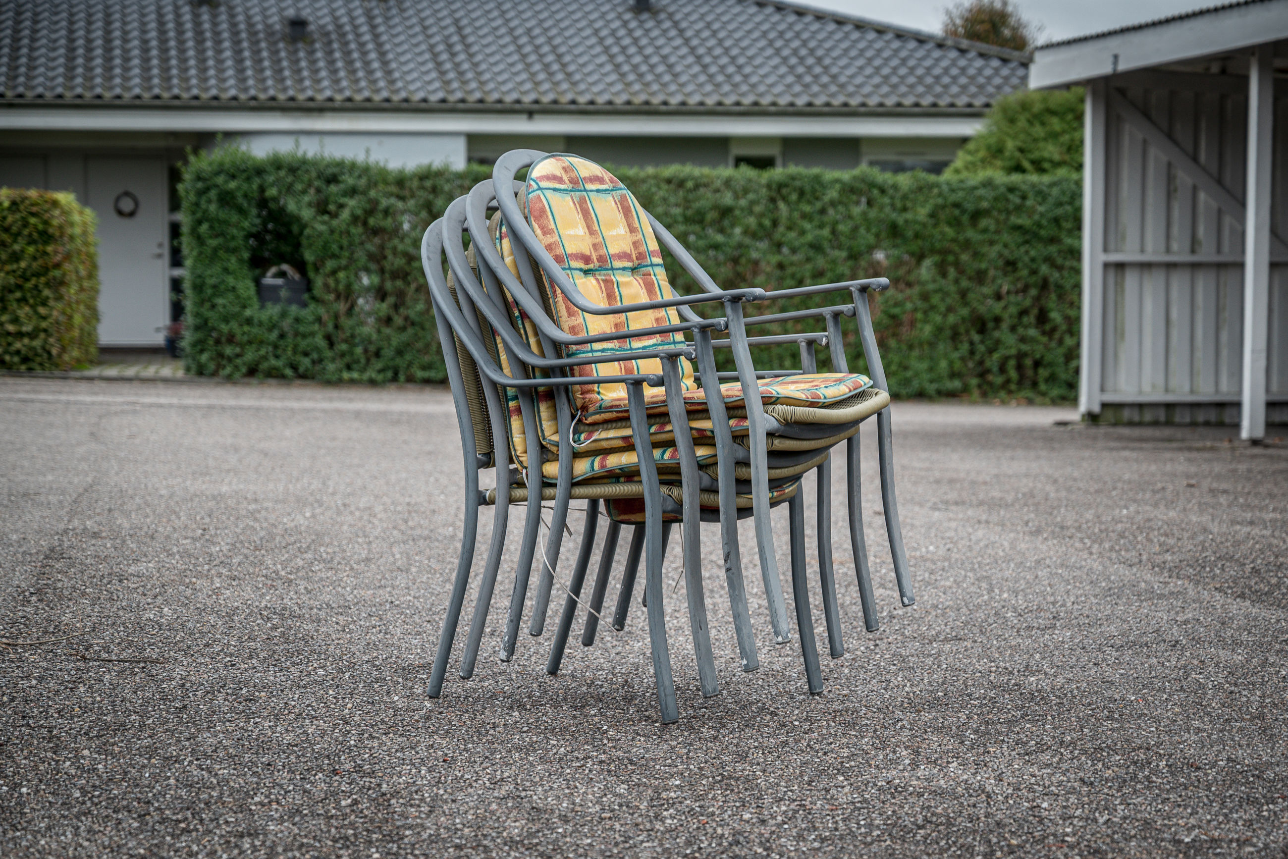 Foto af en stabel ekstra havestole som et eksempel på en genstand, man med fordel kan være fælles om i et delefællesskab.