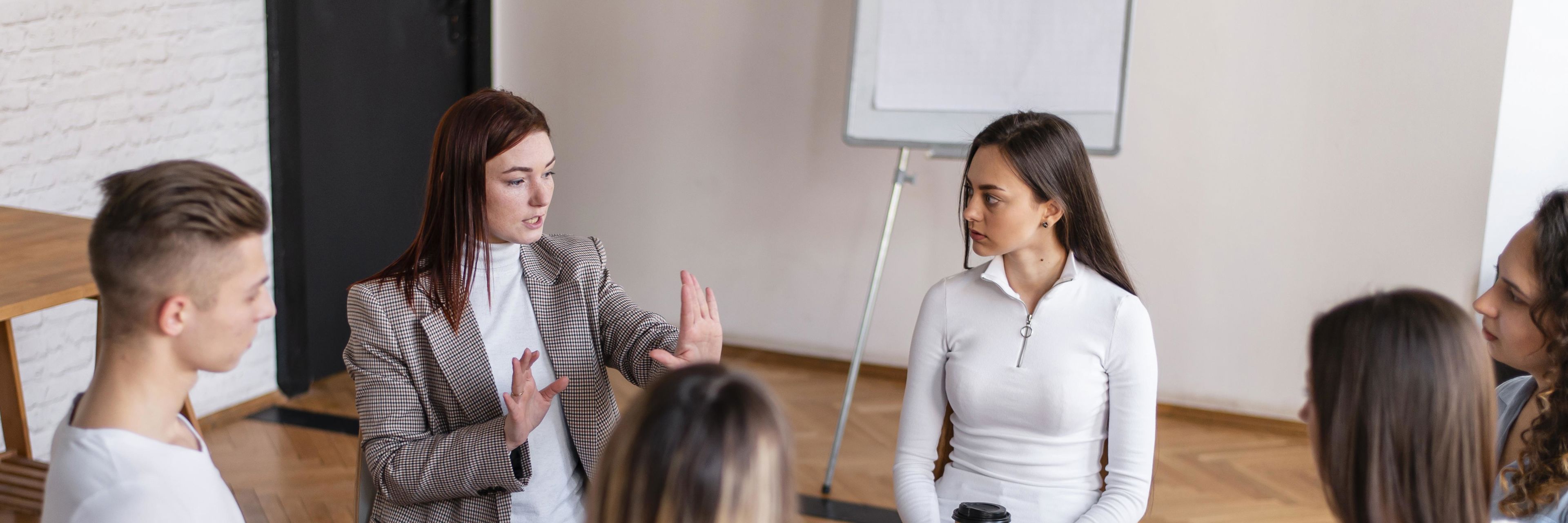 Unge siddende på stole i en rundkreds