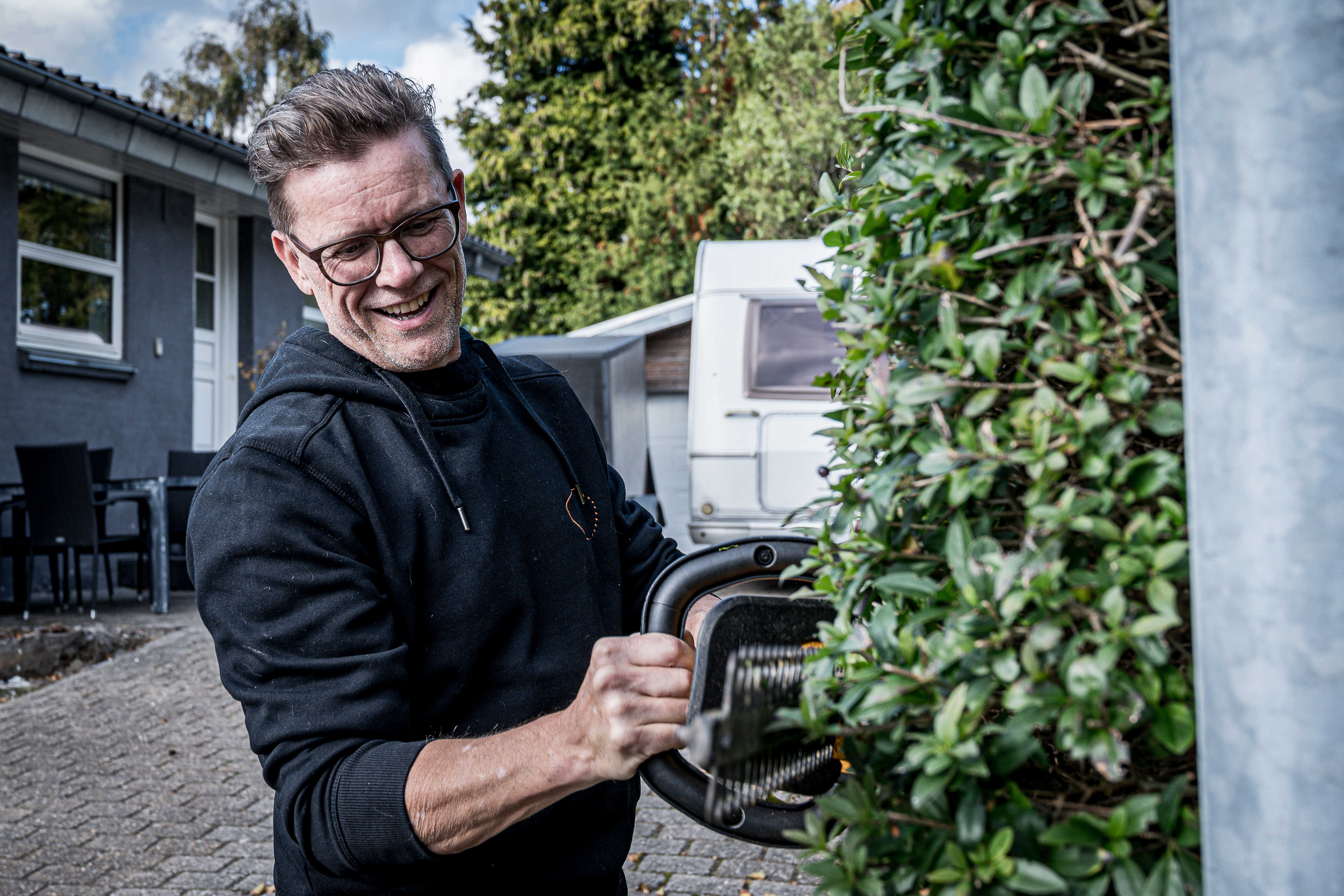 Tomas trimmer hæk med elektrisk hækkeklipper.