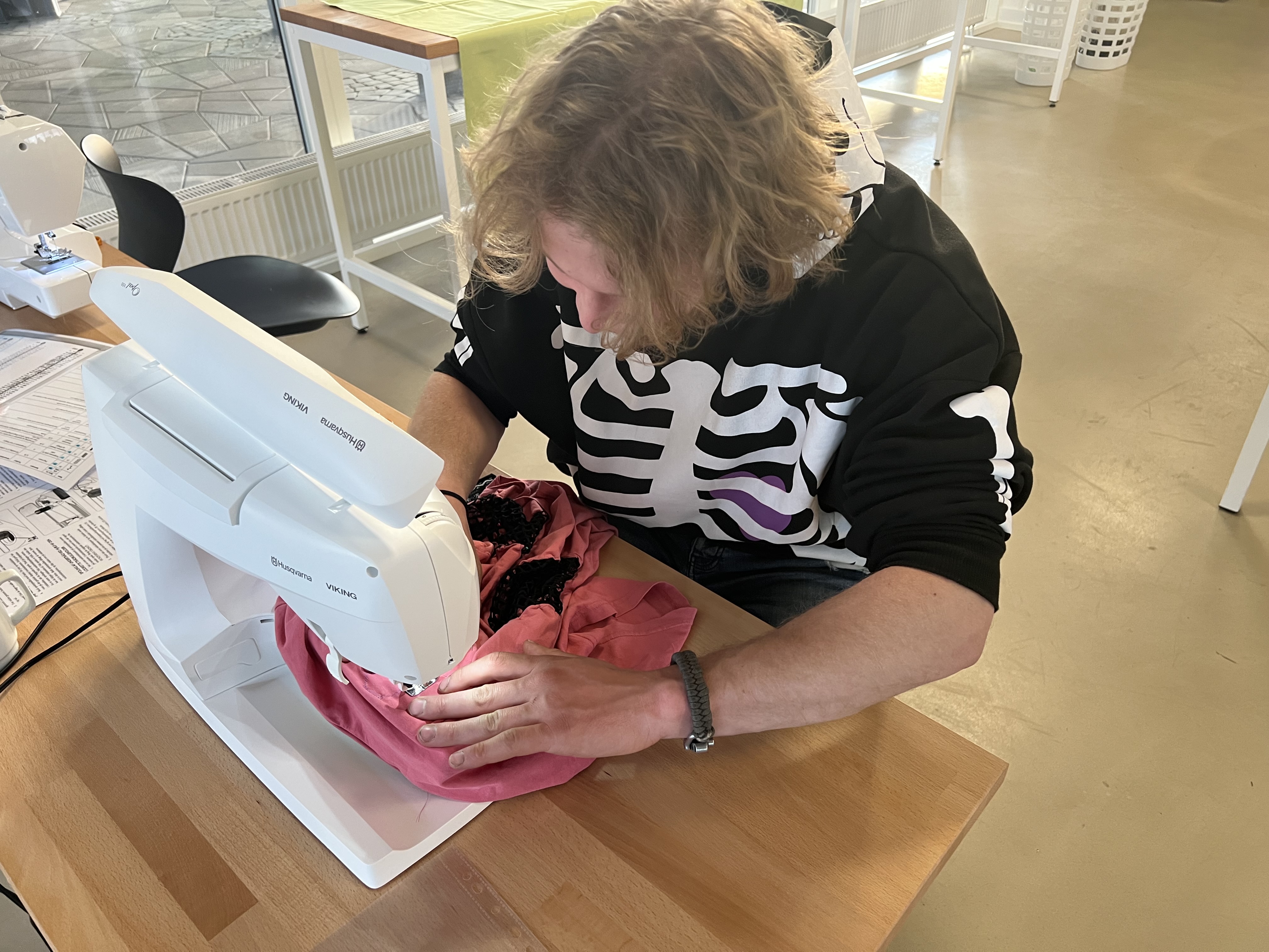 Ung mand arbejder ved symaskine i Laboratoriet på RCV.