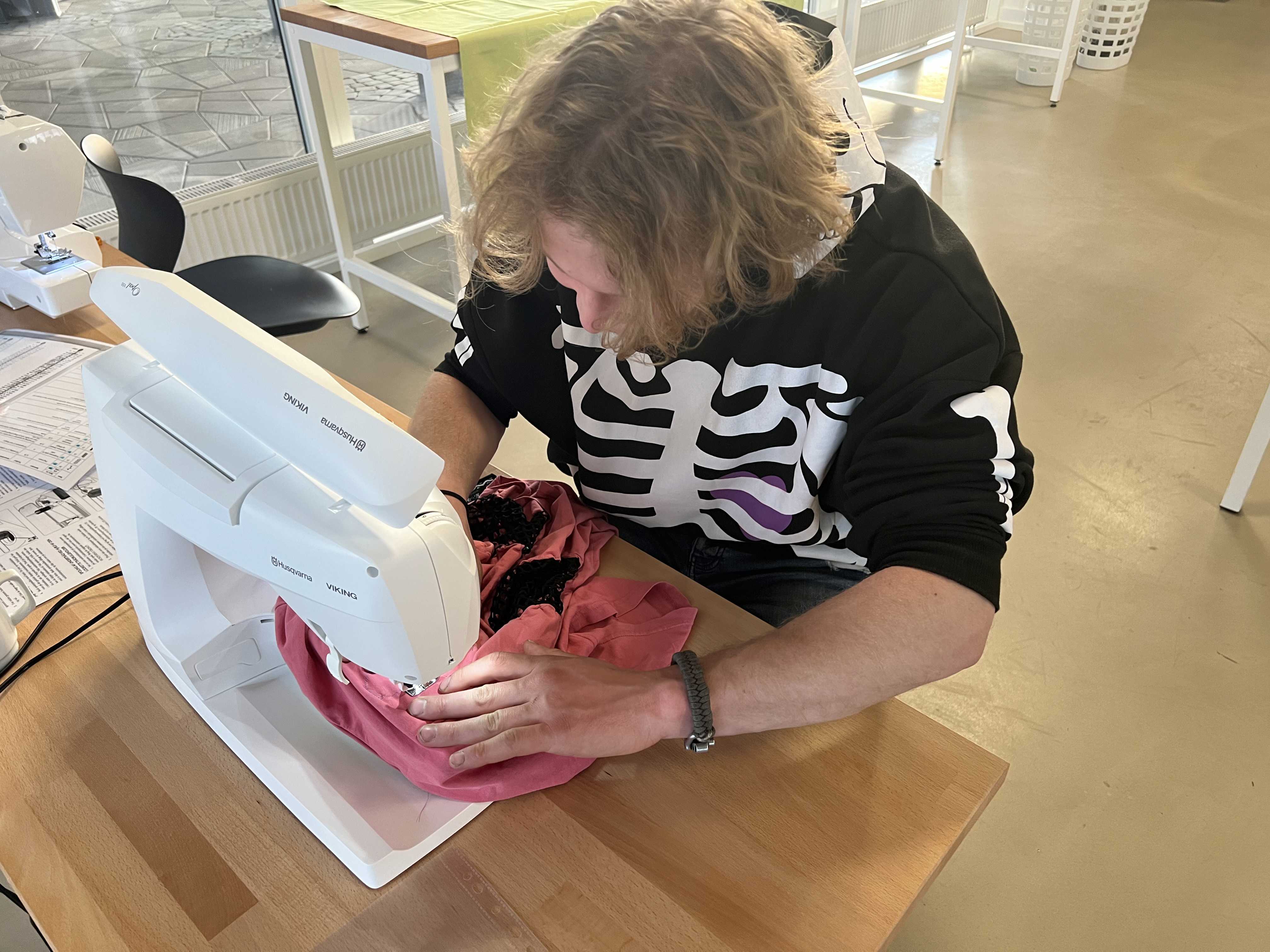 Ung mand arbejder ved symaskine i Laboratoriet på RCV.