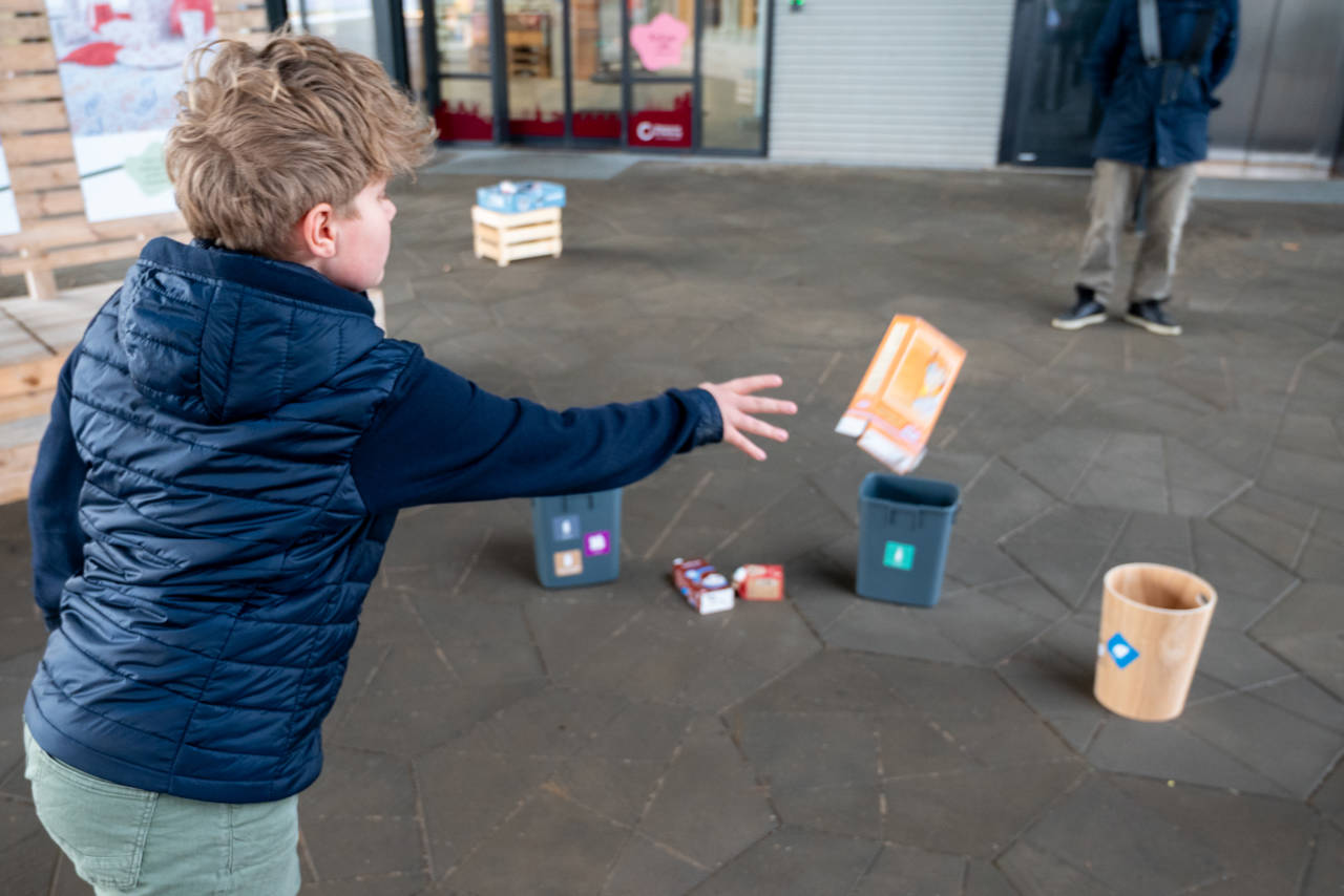 Barn kaster med papcontainer som en del af aktiviteten "affaldsbingo" på Torvet ved RessourceCenter Vejle i forbindelsen med fejringen af RCV's 2-års fødselsdag-