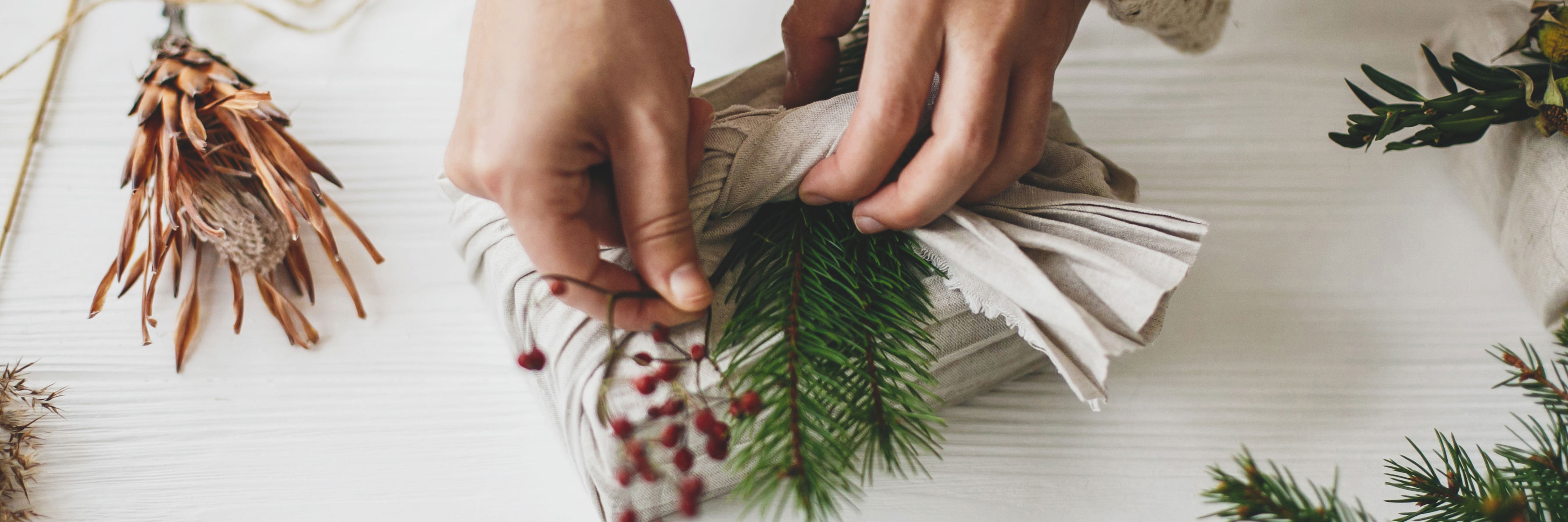 Bæredygtig julegaveindpakning med stof i stedet for gavepapir – en miljøvenlig løsning med naturmaterialer som pynt.