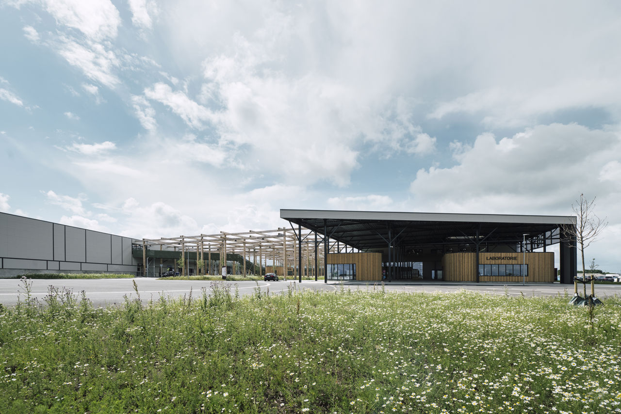 RessourceCenter Vejle (RCV) med grønt tag og solpaneler, omgivet af grønne områder, der viser centerets bæredygtige arkitektur og indre gårdstruktur.