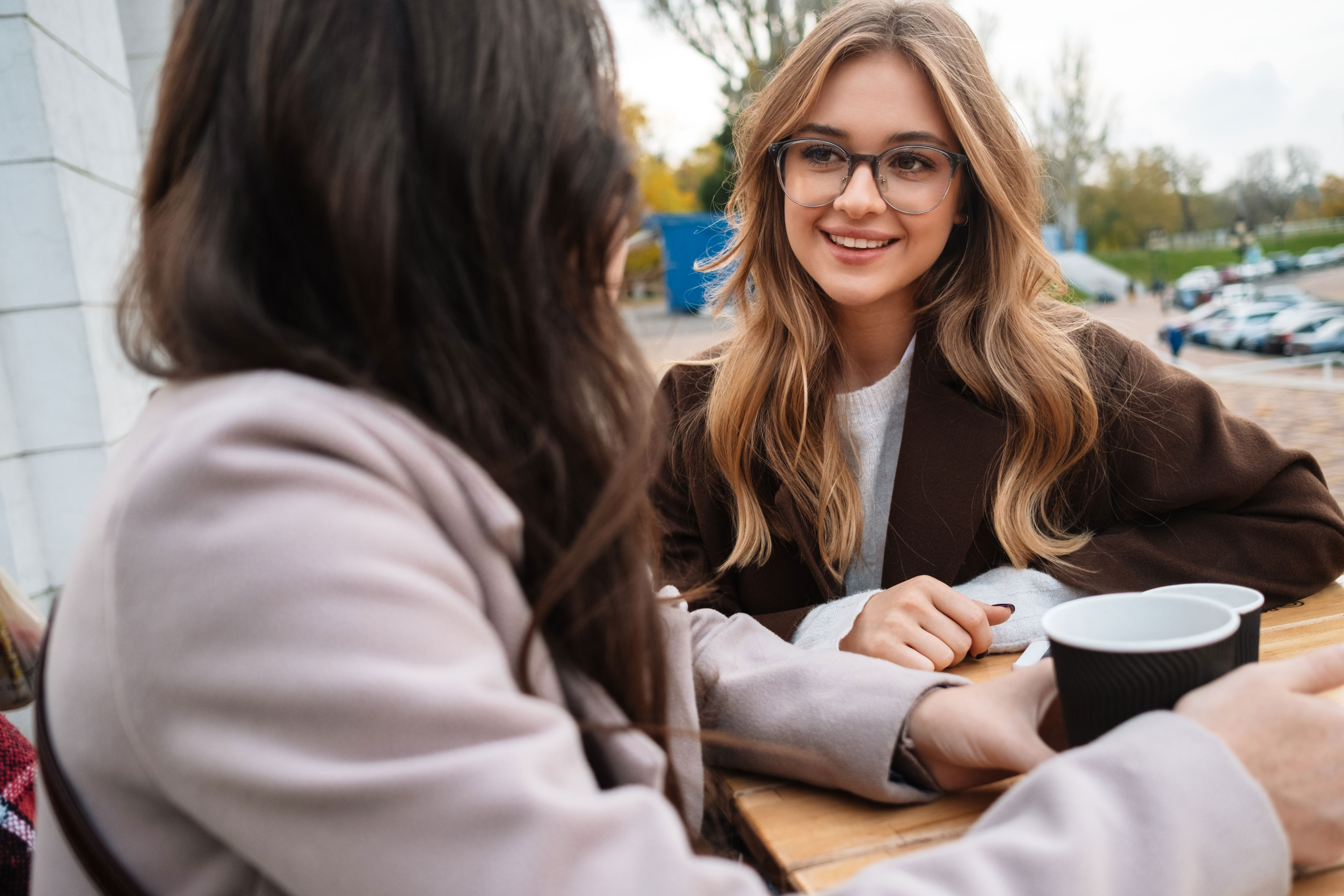 To unge i samtale med kaffekrus