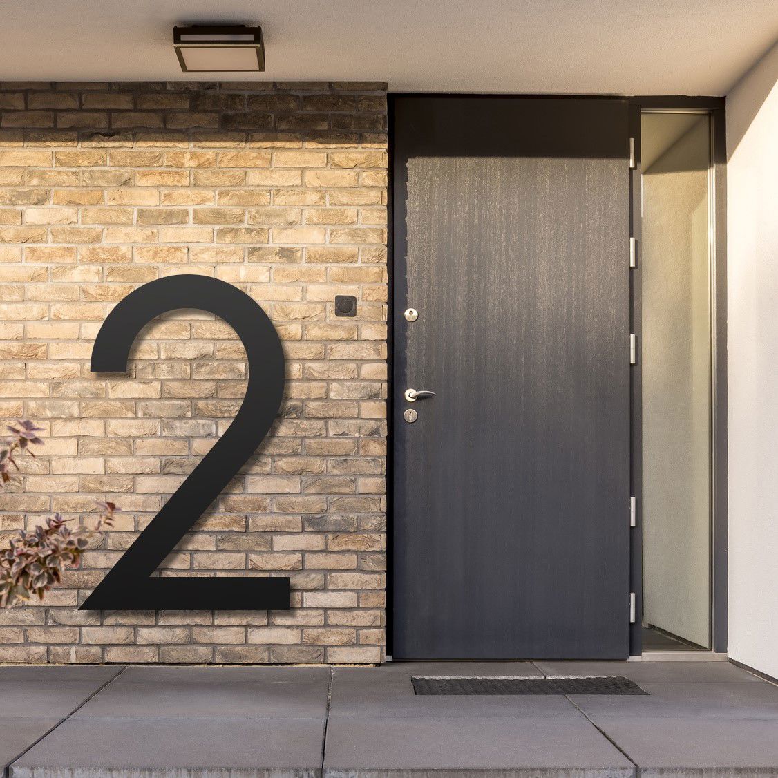 Billedet viser et eksempel på et stort husnummer, ved siden af hoveddøren på en bygning