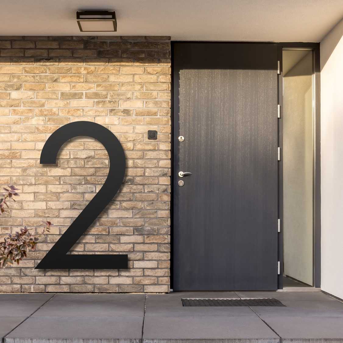 Billedet viser et eksempel på et stort husnummer, ved siden af hoveddøren på en bygning