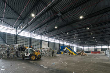 Indvendig hal med affaldshåndtering på RessourceCenter Vejle. Stor industrihal med maskiner og affald i forskellige fraktioner.