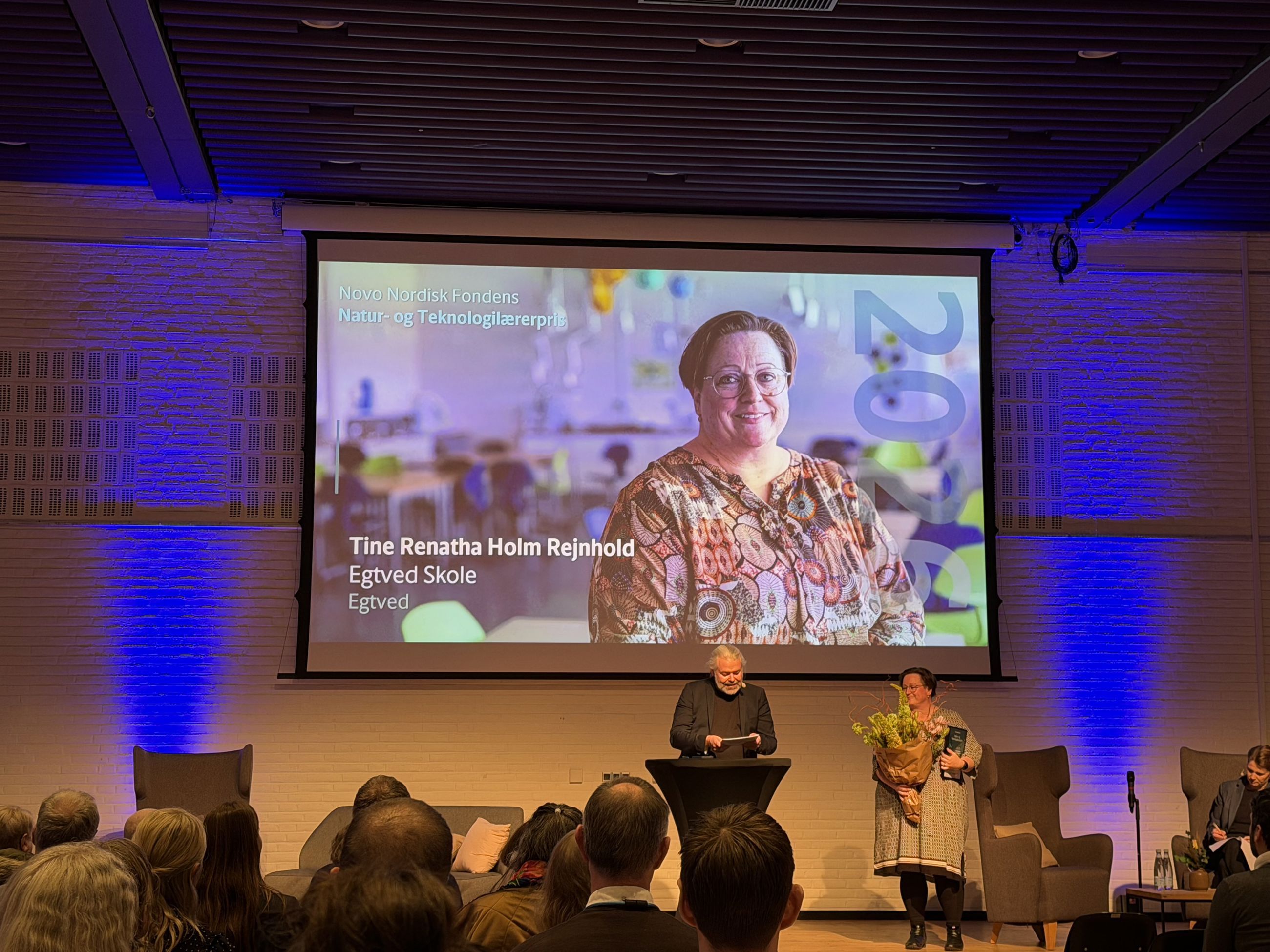 Tine Renatha Holm Rejnhold på scenen til prisoverrækkelsen, hvor hun fik en stor buket blomster og en buket.