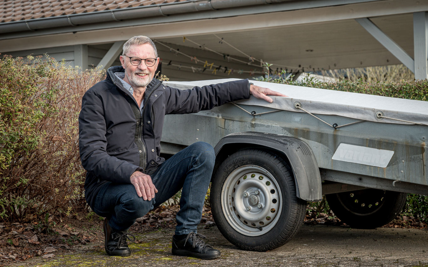 Allan Jensen fra Bredballe sidder på hug foran anhænger på det lille vænges fælles parkeringsplads.