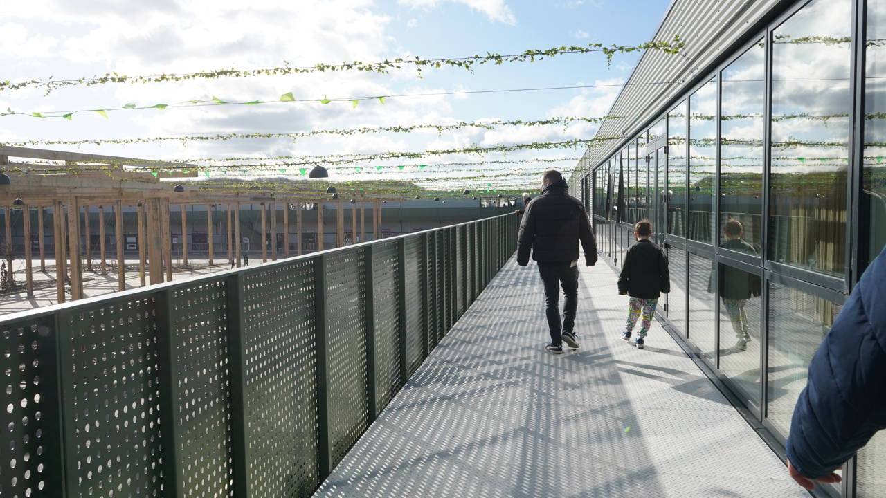 En voksen og et barn ses bagfra, mens de går rundt på Læringsbroen på RCV.