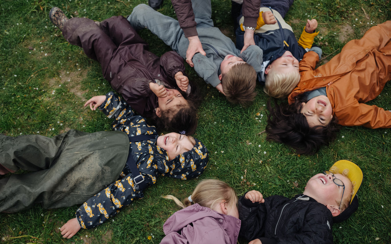 børn ligger på ryggen på græsset
